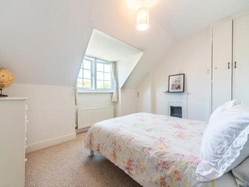 a white bedroom with a bed and a window at Pass the Keys Victorian Flat A Stones Throw From Hampton Court in East Molesey