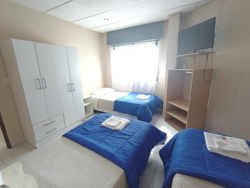 - une petite chambre avec 2 lits et une fenêtre dans l'établissement ALFA SWEET APARTS, à Formosa