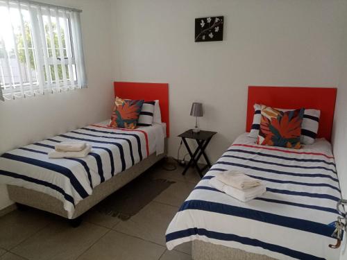 dos camas sentadas una al lado de la otra en una habitación en Covenant Place, en Ciudad del Cabo