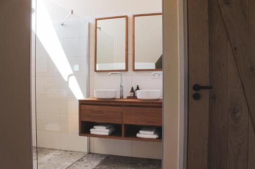 a bathroom with a sink and two mirrors at Slufterhoeve in De Cocksdorp
