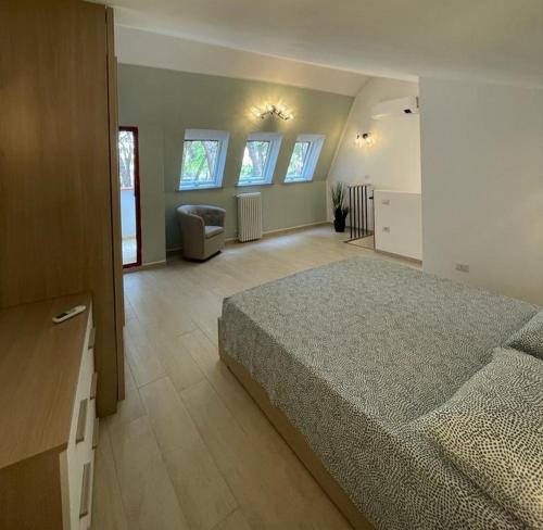 a bedroom with a bed and a couch in it at Appartamento LA ROTONDA in Milano Marittima