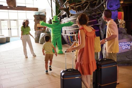 un gruppo di persone in un negozio con un bambino che tira una valigia di Castaway Bay by Cedar Point Resorts a Sandusky