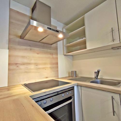 a kitchen with a sink and a stove top oven at Chalet Maurer in Cadipietra