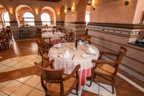 a restaurant with tables and chairs in a room at Hotel Abades Guadix in Guadix