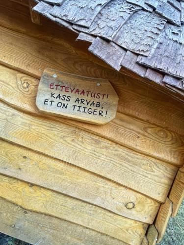 a sign on the side of a wooden building at Künkaotsa in Värati