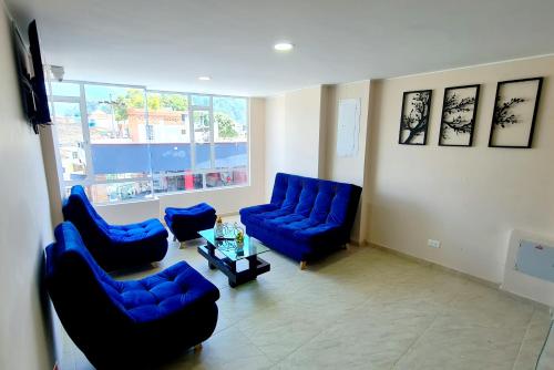 a living room with blue chairs and a table at Hotel San Jose in Duitama