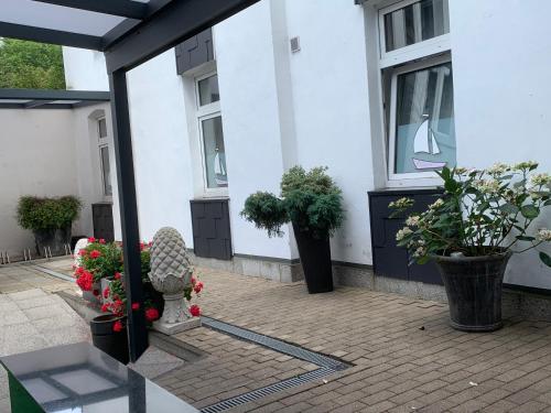 a patio with plants and a statue in front of a building at Hotel am Freihafen in Duisburg