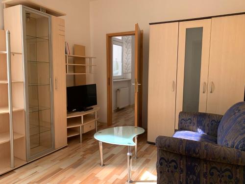 a living room with a couch and a table and a tv at Hotel am Freihafen in Duisburg