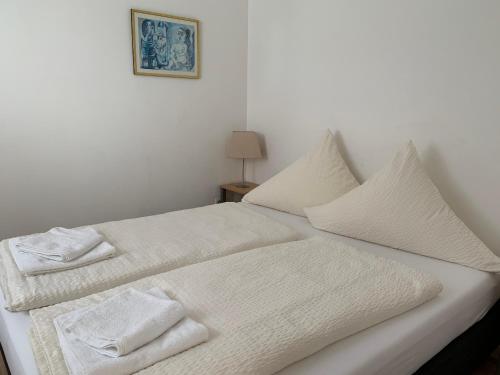 Una cama blanca con toallas blancas encima. en Hotel am Freihafen, en Duisburg