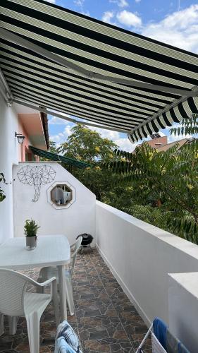 - un patio blanc avec une table et des chaises sur un mur blanc dans l'établissement ART ATELIER GERI with a terrace, free parking & wi-fi, à Blagoevgrad