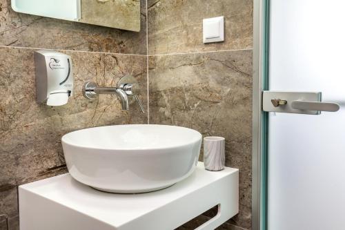 a bathroom with a white sink on a counter at New Azzurro Deluxe in Limenaria