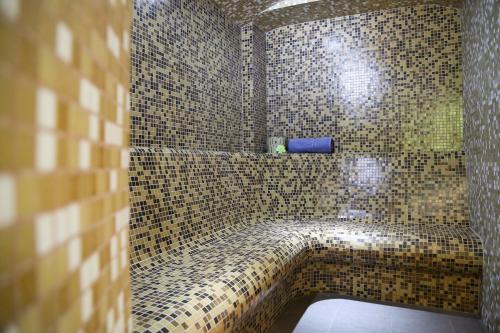 a bathroom with a walk in shower with brown tiles at Oblique - Forest & Spa in Sinaia