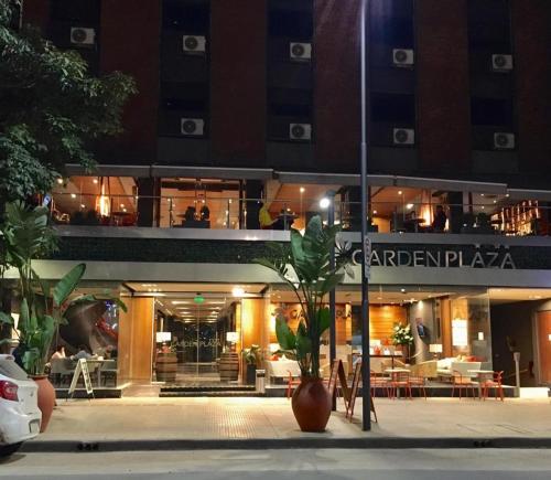 a building with a restaurant in front of it at night at Garden Plaza in San Miguel de Tucumán