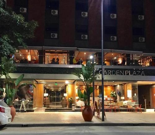 un edificio con un restaurante delante de él por la noche en Garden Plaza en San Miguel de Tucumán