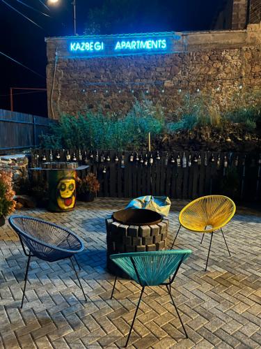 a group of chairs and tables on a patio at night at Kazbegi Apartments in Stepantsminda