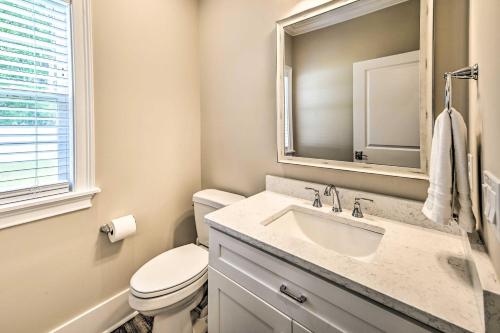 a bathroom with a toilet and a sink and a mirror at Charming Pawleys Island Home about 4 Mi to Beach! in Pawleys Island