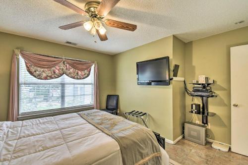 a bedroom with a bed with a ceiling fan and a window at Hampton Home with Fireplace and Close to Beaches! in Hampton