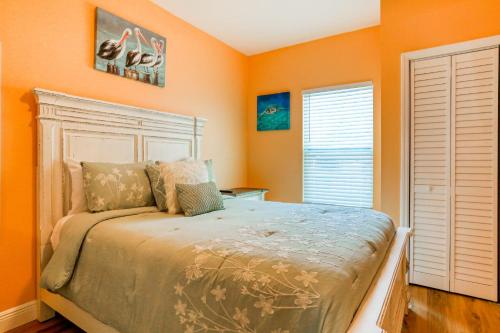 1 dormitorio con paredes de color naranja y 1 cama en East Shore Paradise #448, en Clearwater Beach