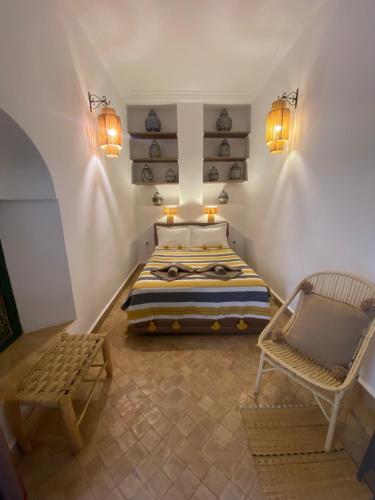 1 dormitorio con cama, silla y luces en Riad Al Karama, en Marrakech