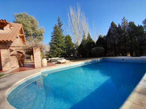 una gran piscina azul en un patio en La Bignonia Posada en Chacras de Coria