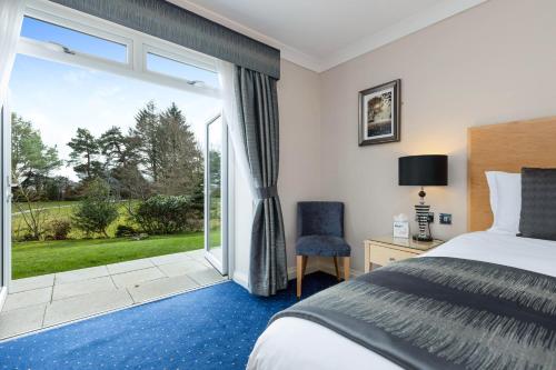 a hotel room with a bed and a large window at The Moorland Hotel, Haytor, Devon in Haytor