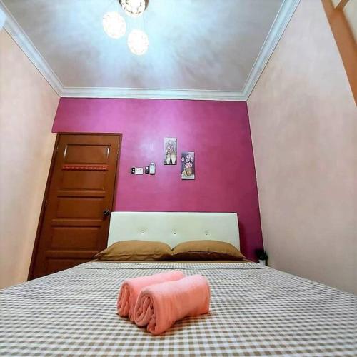 a bedroom with a bed with a pink wall at Comfy Stay @Permai Puteri Ampang nearby KLCC, IJN in Ampang
