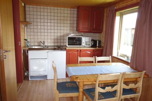 a kitchen with red cabinets and a table with chairs at Høvringen Fjellstue in Høvringen