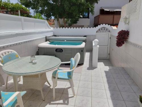 a patio with a table and chairs and a grill at Jacuzzi House Sunflower in Costa Del Silencio