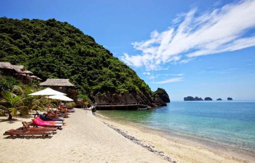 una playa con sillas y sombrillas y el océano en Catba View Hotel, en Cat Ba