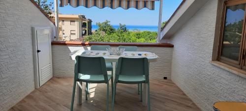 un tavolo e sedie su un balcone con vista sull'oceano di Villa Gentile ad Acciaroli