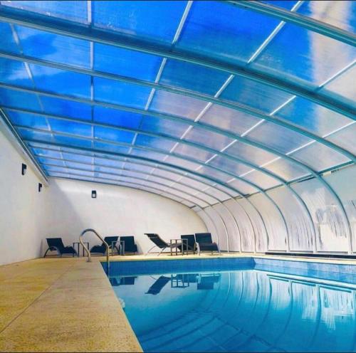 una piscina cubierta con techo azul en Departamentos Casa del Parque en Necochea