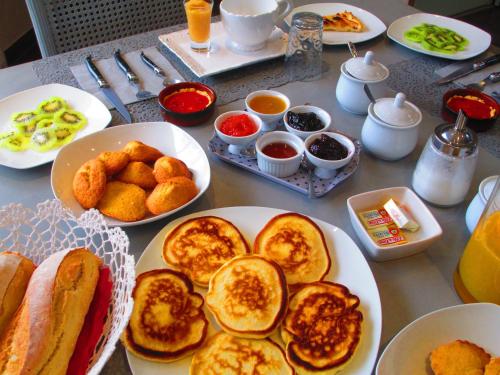- une table avec des assiettes de petit-déjeuner dans l'établissement Le Mas du Fort, à Neyron