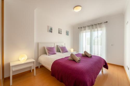 a bedroom with a large bed with a purple blanket at Casa Boa Onda in Nazaré