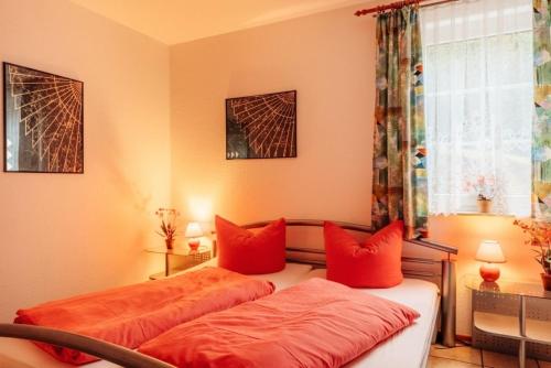 2 Betten in einem Zimmer mit roten Kissen in der Unterkunft Ferienwohnung LePetit in Steina