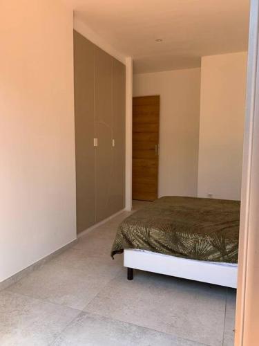 - une chambre avec un lit et une porte menant à un placard dans l'établissement Maison neuve avec piscine et terrasse extérieur, à Corbara