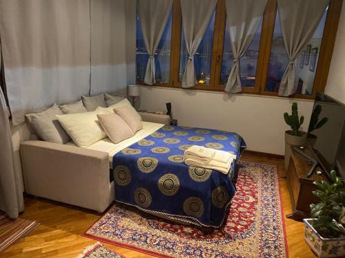 een bed in een kamer met een bank en een tapijt bij Casa MaLù in Messina