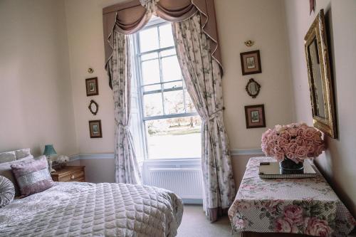 a bedroom with a bed and a window at Walcot Hall - Stunning Stately Home set in 27 acres of parkland and sleeping 16+ in Alkborough