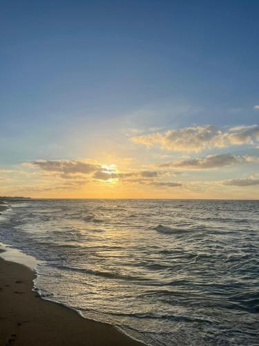 a sunset over the ocean on a beach at Havre de paix au BahiaGolf Beach, Résidence Front Mer in Bouznika