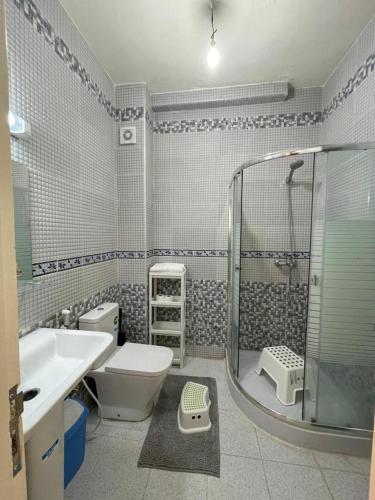een badkamer met een douche, een toilet en een wastafel bij Ifrane Appartment in Ifrane