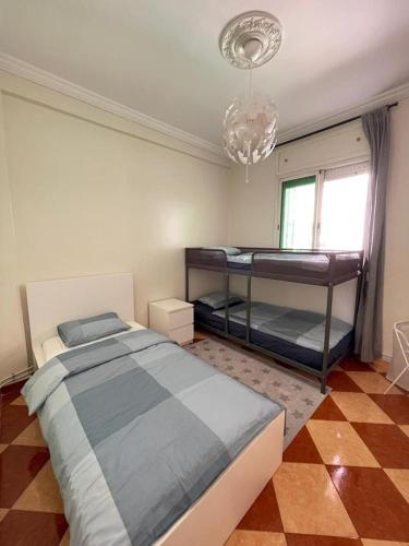 a bedroom with two bunk beds and a chandelier at Ifrane Appartment in Ifrane