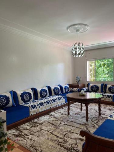 a living room with a blue couch and a table at Ifrane Appartment in Ifrane