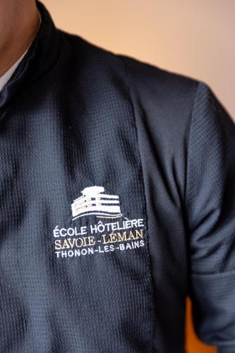 a man wearing a blue jacket with a white logo at Hôtel Savoie Léman in Thonon-les-Bains