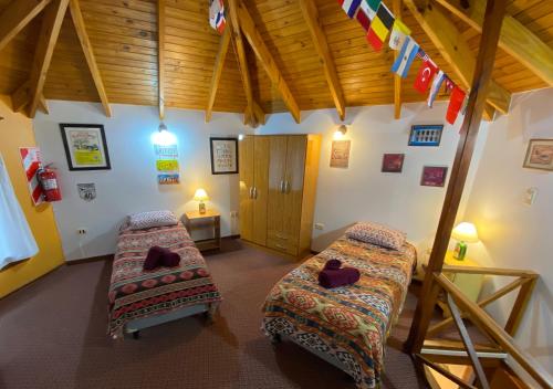 Cette chambre dispose de deux lits et d'un plafond en bois. dans l'établissement Mansion Verde, à El Calafate