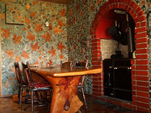 cocina con mesa de madera y pared de ladrillo en Little Paradise Lodge, en Creighton