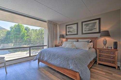 a bedroom with a bed and a large window at Pawleys Island Condo Retreat with Beach Access! in Pawleys Island