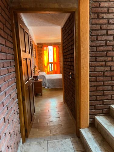 a hallway with a brick wall and an open door at Casa Diez-59 Guanajuato Capital in Guanajuato