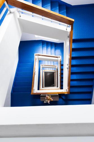 a blue staircase with a mirror in a room at Hôtel Savoie Léman in Thonon-les-Bains