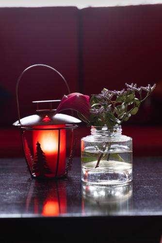 a candle and a vase with flowers on a table at Hôtel Savoie Léman in Thonon-les-Bains