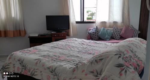 a bedroom with a bed with a tv on a table at Studio Canto Forte - Praia Grande in Praia Grande