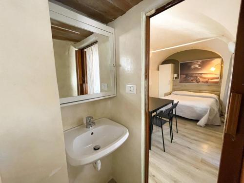 un bagno con lavandino e una camera con letto di Monolocale a 50 metri dal mare a Celle Ligure